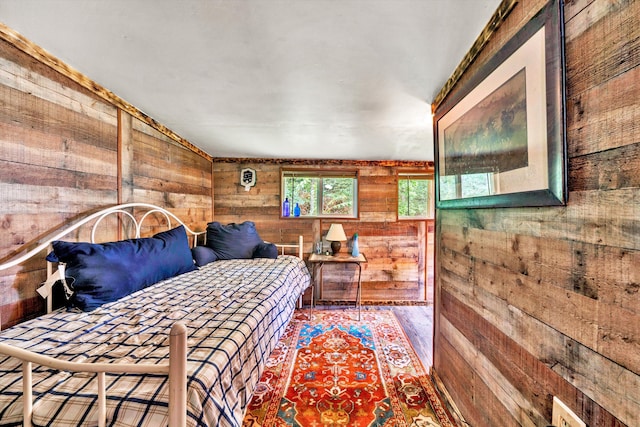 bedroom with hardwood / wood-style flooring and wood walls