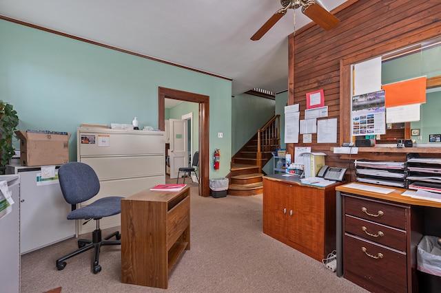 office space with wood walls, light colored carpet, ornamental molding, and ceiling fan