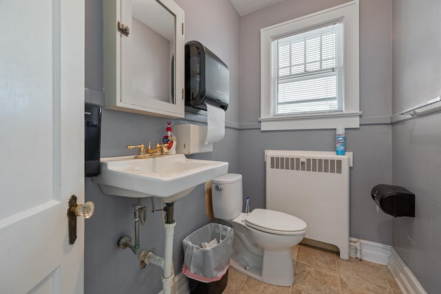 bathroom featuring tile patterned floors, toilet, and radiator