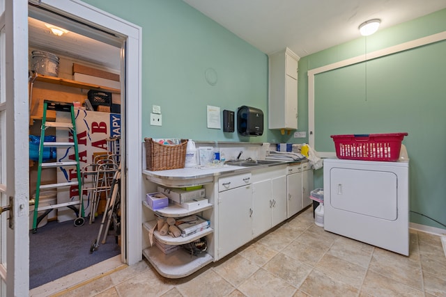 clothes washing area with washer / clothes dryer, sink, cabinets, and light tile patterned floors