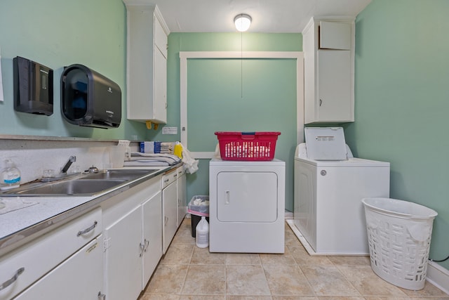 laundry room featuring light tile patterned flooring, sink, separate washer and dryer, and cabinets