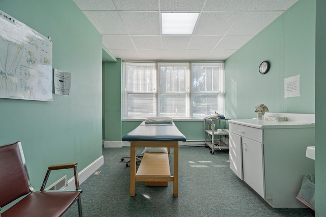 carpeted office space with a paneled ceiling