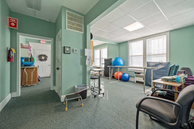 interior space featuring radiator heating unit, carpet floors, and a paneled ceiling