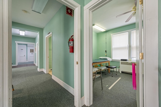 hallway featuring carpet flooring and radiator heating unit