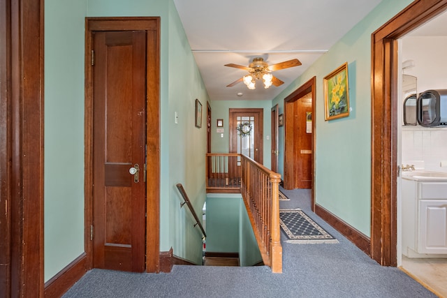 corridor featuring sink and carpet