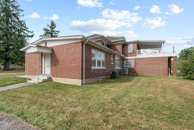 exterior space with a balcony, a lawn, and central AC unit