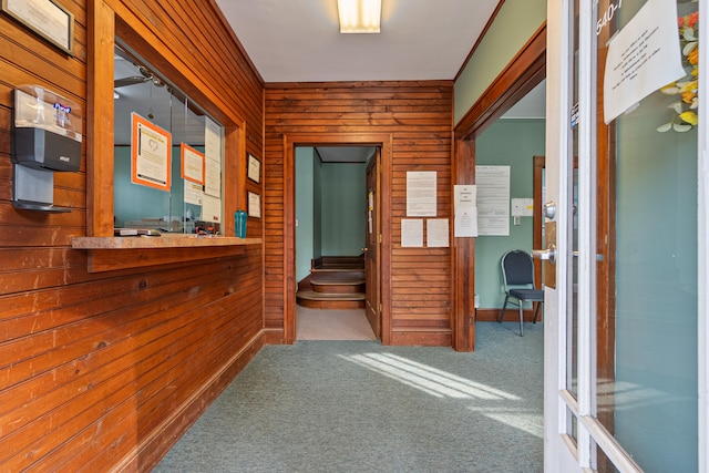 corridor featuring carpet and wooden walls