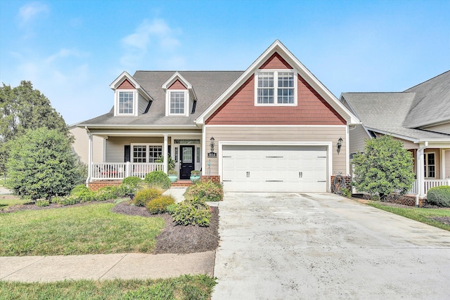 view of front of property featuring a porch, a garage, and a front yard