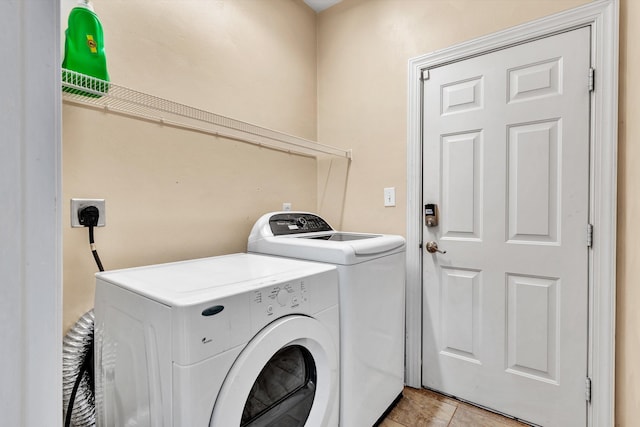 laundry room featuring separate washer and dryer and light tile patterned floors