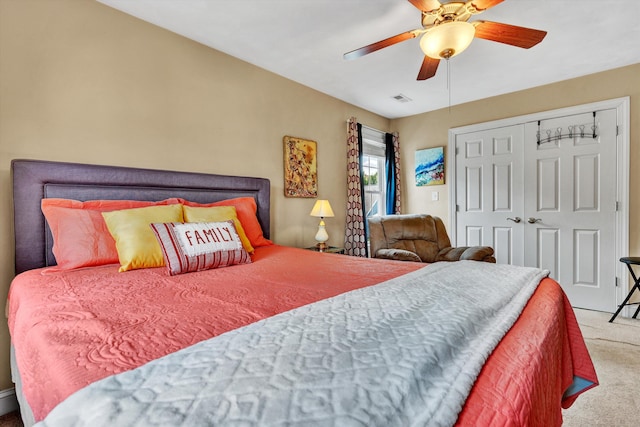 carpeted bedroom with ceiling fan and a closet