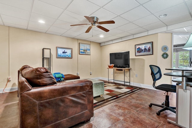 living room featuring ceiling fan and a drop ceiling