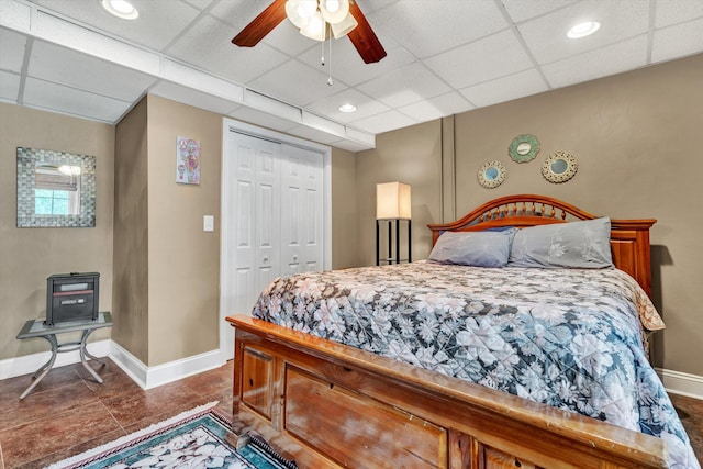 bedroom featuring dark tile patterned floors, a paneled ceiling, a closet, and ceiling fan