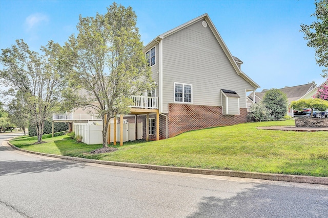 view of home's exterior with a wooden deck and a yard