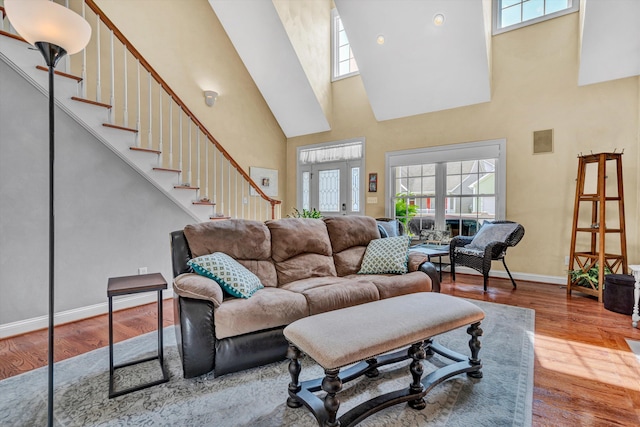 living room with a towering ceiling and hardwood / wood-style floors