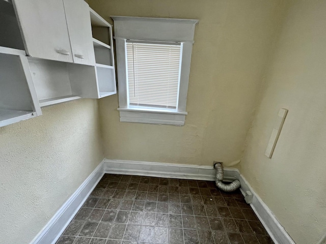 laundry area featuring cabinets and tile patterned flooring