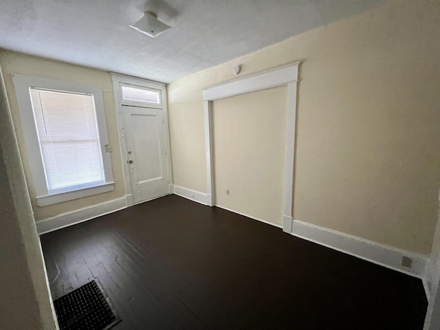 entryway featuring a textured ceiling and dark hardwood / wood-style floors