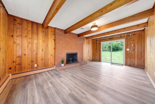 unfurnished living room with light hardwood / wood-style flooring, wooden walls, beamed ceiling, and a brick fireplace