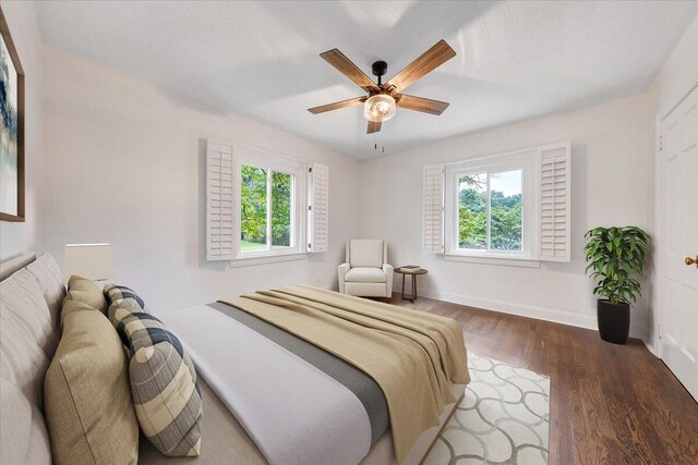 bedroom featuring multiple windows, hardwood / wood-style floors, and ceiling fan