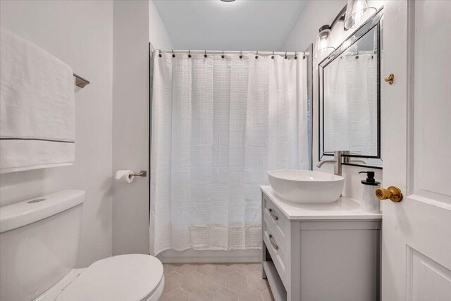 bathroom with toilet, vanity, and tile patterned floors