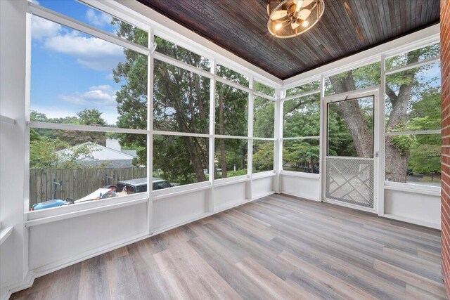 unfurnished sunroom featuring wooden ceiling and a chandelier