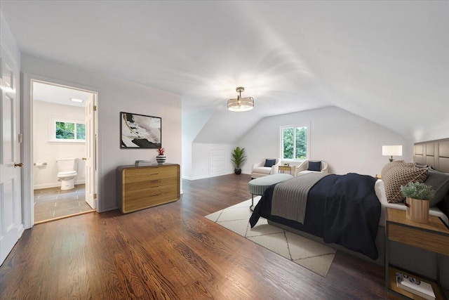 bedroom featuring vaulted ceiling, connected bathroom, and hardwood / wood-style floors