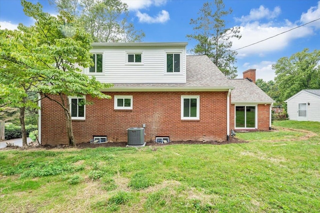 back of house featuring central AC unit and a lawn