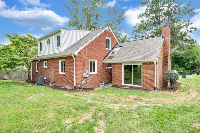 back of house featuring central AC and a yard