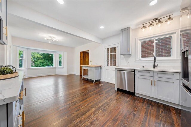 kitchen featuring sink, dark hardwood / wood-style flooring, beam ceiling, gray cabinetry, and stainless steel appliances