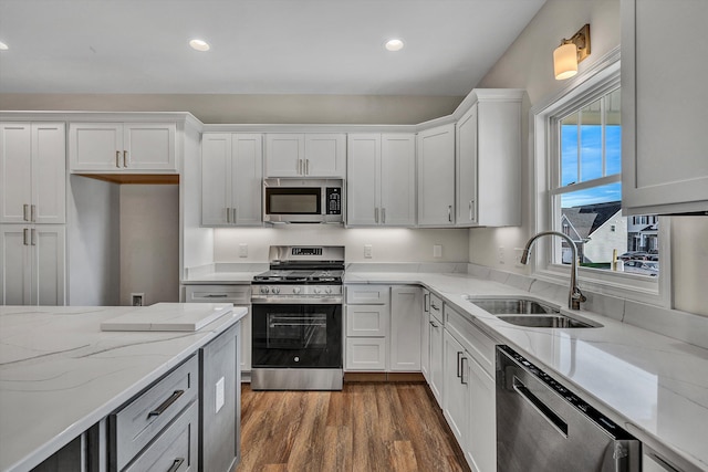 kitchen with dark wood-type flooring, white cabinetry, sink, and stainless steel appliances