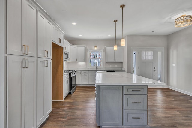 kitchen featuring decorative light fixtures, a center island, stainless steel appliances, and dark hardwood / wood-style floors