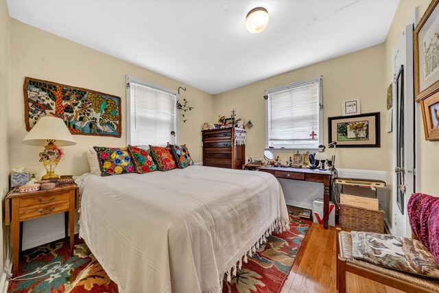 bedroom with multiple windows and light wood-type flooring