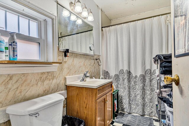 bathroom with tile walls, toilet, and vanity