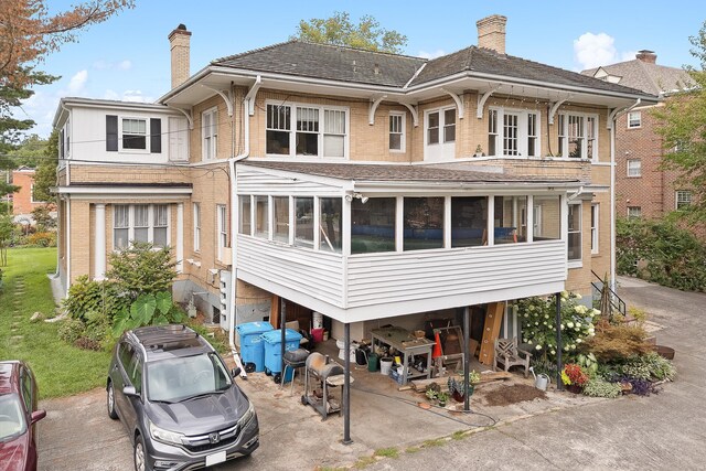 rear view of property featuring a sunroom