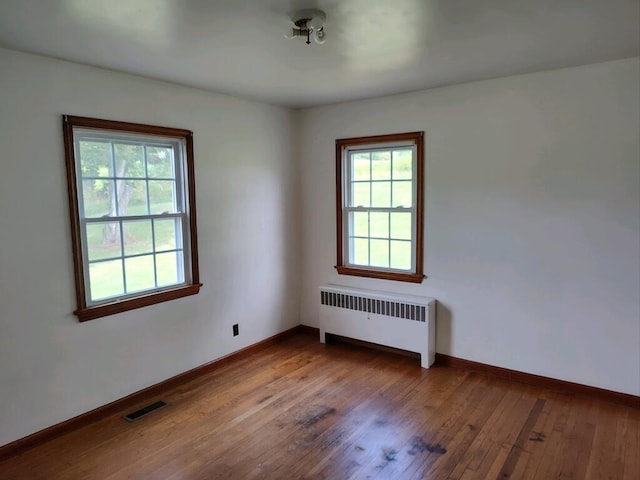 spare room with wood-type flooring and radiator