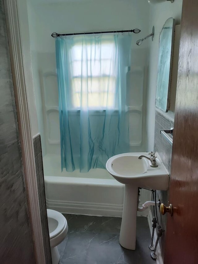 bathroom featuring tub / shower combination, toilet, and tile patterned flooring