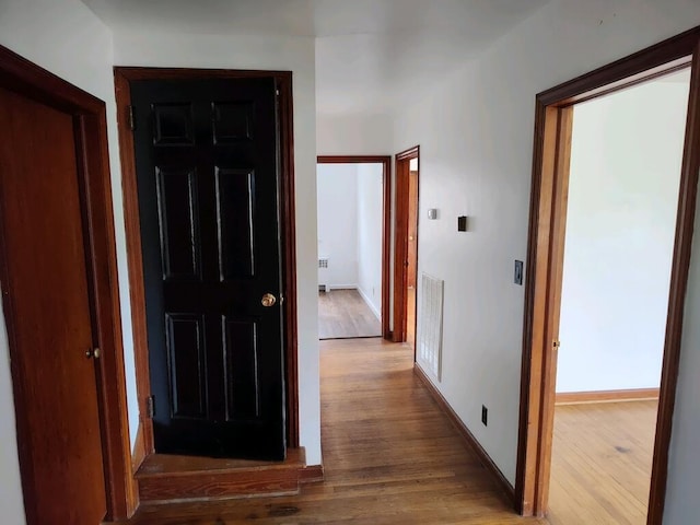 hall featuring radiator heating unit and hardwood / wood-style floors