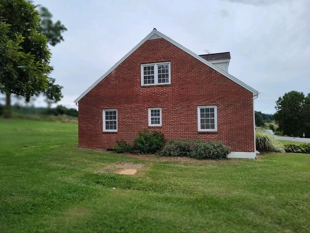 view of side of home with a yard