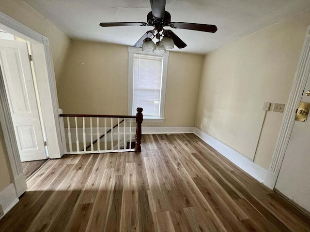 empty room with hardwood / wood-style floors and ceiling fan