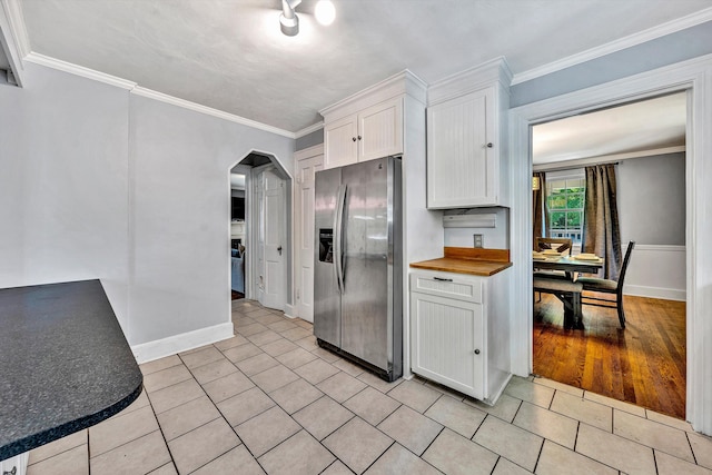 kitchen with ornamental molding, stainless steel fridge, white cabinetry, and light hardwood / wood-style floors