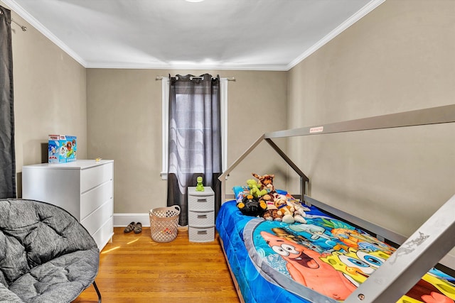 bedroom with light wood-type flooring and crown molding