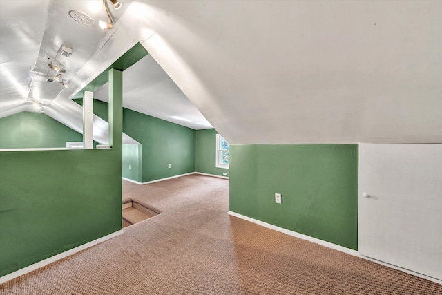 additional living space with vaulted ceiling and carpet flooring