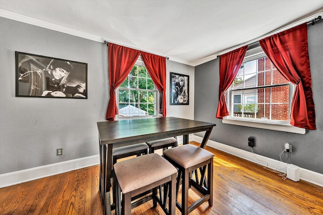 dining area featuring hardwood / wood-style floors and crown molding