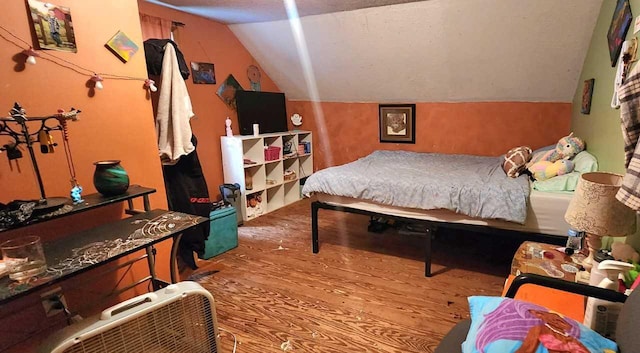 bedroom with vaulted ceiling and wood-type flooring