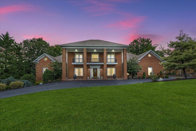 view of front of property with a balcony and a yard