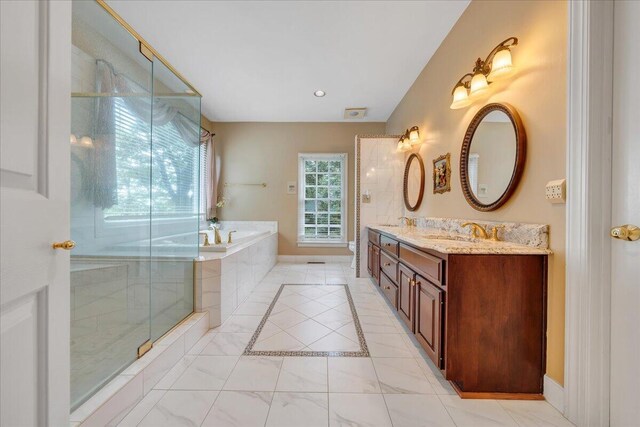 bathroom featuring vanity and independent shower and bath