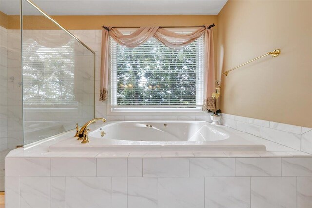 bathroom with a relaxing tiled tub