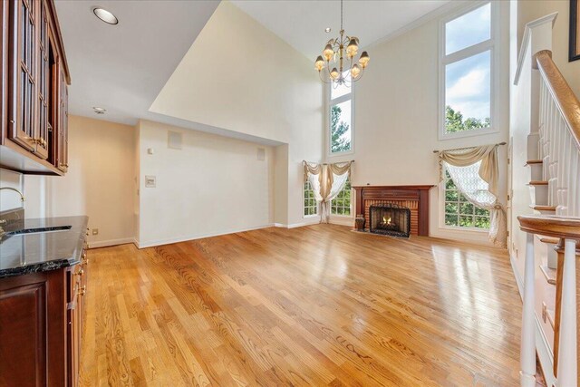 living room with sink, a wealth of natural light, a brick fireplace, and light wood-type flooring