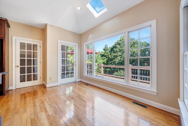 unfurnished sunroom featuring a skylight