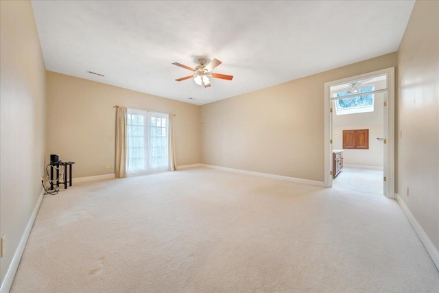 spare room featuring light carpet and ceiling fan