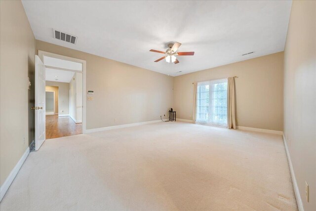 carpeted spare room featuring ceiling fan